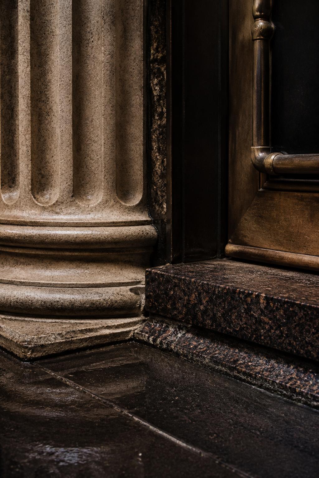 Stone column and metal doorway of an institutional building