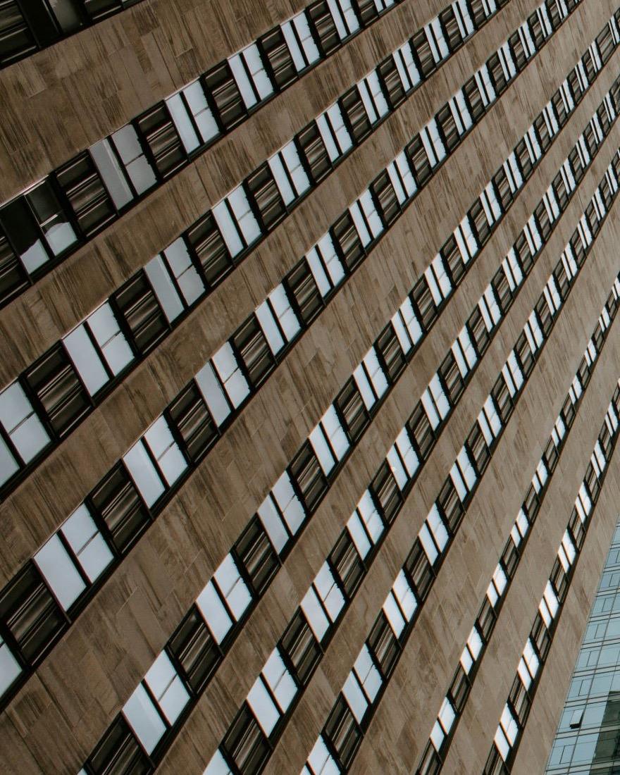 Rising stone façade with a repeating window grid — scale, order and vertical depth