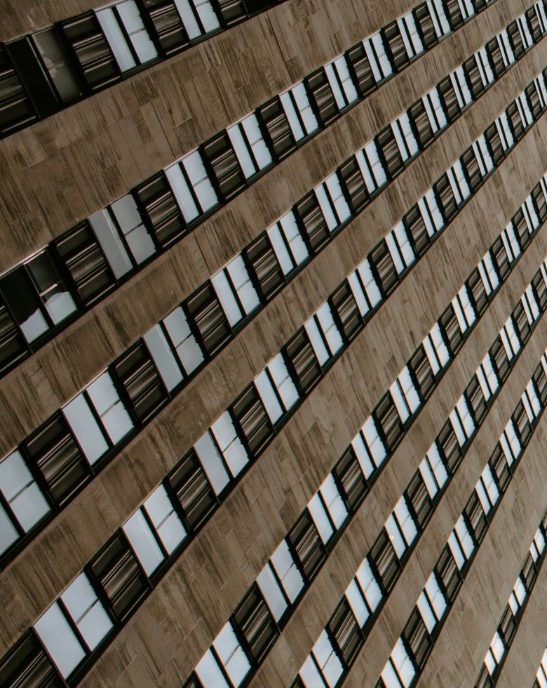 Close crop of a stone office facade and window grid, looking up