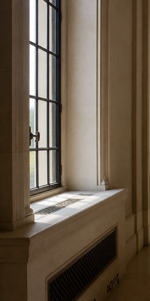 Lattice of window panes filtering a view through stone
