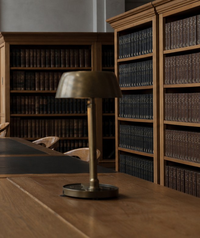 Brass lamp and timber desk in an ordered institutional workplace